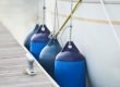 close up of blue fenders on a boat at a dock