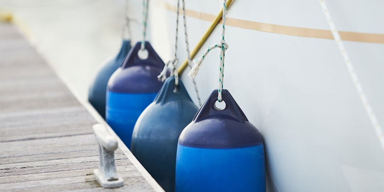 close up of blue fenders on a boat at a dock